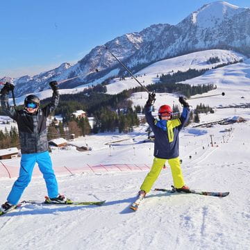 Zwei jugendliche Skifahrer bei strahlendem Sonnenschein auf der Postalm