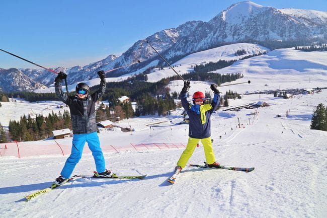 Zwei jugendliche Skifahrer bei strahlendem Sonnenschein auf der Postalm